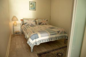 a bedroom with a bed and a night stand with a lamp at SUNSET GETAWAY GLENELG in Glenelg