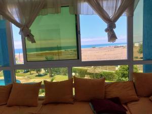 ein Wohnzimmer mit einem Sofa und einem großen Fenster in der Unterkunft Piso vistas al mar in Asilah