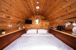 un grande letto in una camera con soffitto in legno di Delny Glamping and Farm Animals a Invergordon