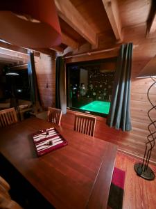 a dining room with a table and a pool at Le chalet du Cerf - Chambre d'hôte in Somme-Leuze