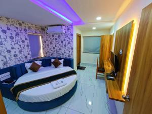 1 dormitorio con 1 cama grande y paredes moradas en HOTEL ROCK en Anand