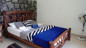 um quarto com uma cama de madeira num quarto com uma ventoinha em Ella Lucky Panoramic em Ella