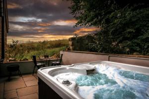 a jacuzzi tub sitting on a patio with a sunset at The Auld Reekie in Barbaraville