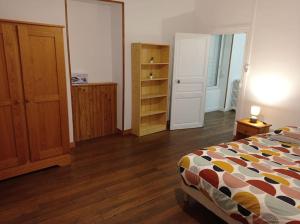 Schlafzimmer mit einem Bett und Holzboden in der Unterkunft Appartement centre Saulieu in Saulieu