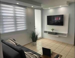 a living room with a couch and a tv at cozy private apartment near sju airport in Carolina