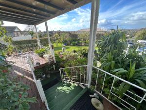 uma vista para um jardim a partir da varanda de uma casa em Lucky house em Auckland