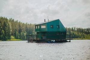 PaķulesFloating guest house Musters的湖中码头上的房屋