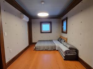 1 dormitorio con 1 cama en el centro de una habitación en Basecamp Pension, en Pohang