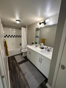 a bathroom with two sinks and a toilet and a mirror at Charming 1,100 sq ft apartment near to The Shops at Legacy in Plano