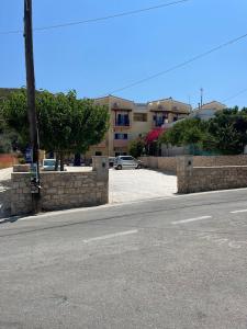 an empty street with a brick wall and a building at STUDIOS ATHENA in Megalochori