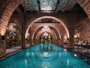 uma piscina interior num edifício de tijolos com um lustre em Ananti at Gangnam em Seul