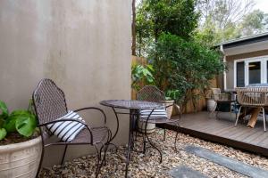 a patio with chairs and tables on a deck at Eggies Nest - Sydney City Apartment in Sydney