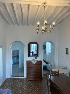una sala da pranzo con un tavolo e un lampadario di Cycladic house with amazing view in Potamia village a Dhió Kkhoriá