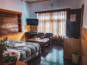 a living room with a couch and a table at Hotel shaynam in Leh