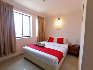a bedroom with a large bed with red pillows and a window at HOTEL PANTAI VIEW in Labuan