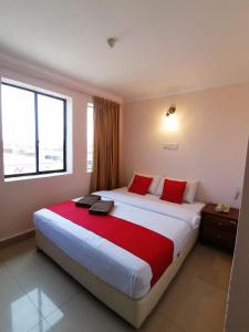 納閩的住宿－HOTEL PANTAI VIEW，酒店客房配有一张带红色枕头的大床