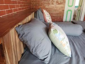 a bed with two pillows and a brick wall at Pondok isoke bunggalow in Banyuwangi