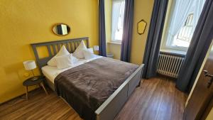 a bedroom with a large bed with yellow walls at RATSKELLER Hotel & Restaurant in Kröv