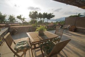 Wood&Stone Guesthouse في Almirón: طاولة وكراسي خشبية على الفناء