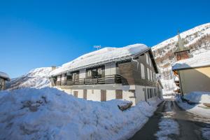 a building covered in snow next to a road at Résidence Igloo 3 ski in-ski out - Happy Rentals in Le Tour