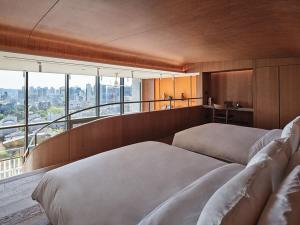 a bedroom with two beds and a balcony at Ananti at Gangnam in Seoul