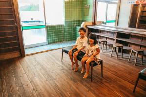 dos niños sentados en sillas en un aula en Yado Charinko, en Gose