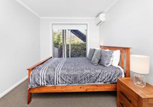 Schlafzimmer mit einem Bett und einem Fenster in der Unterkunft Cookes Haven in Gerringong