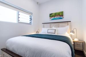 a bedroom with a large white bed with a window at Eggie's Nest - Luxury City Apartment in Sydney