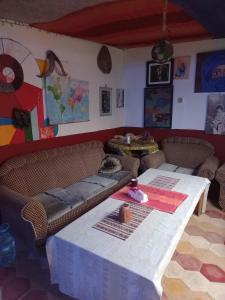 uma sala de estar com uma mesa e um sofá em Kasba de l'artiste em Mirleft