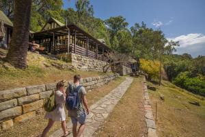 a man and a woman walking towards a building at YHA Pittwater Eco, Sydney in Church Point