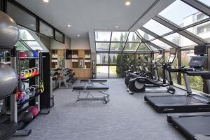 a gym with a lot of treadmills and machines at Courtyard by Marriott Norwalk in Norwalk