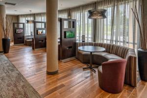 a lobby with a couch and a table and chairs at Courtyard by Marriott Troy in Troy