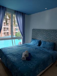 une chambre bleue avec un lit avec un chapeau dessus dans l'établissement Atlantis Condo Resort Атлантис кондо резорт, à Jomtien Beach 267 autres photos