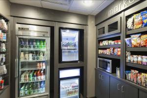 a store aisle with two refrigerators and drinks at Courtyard by Marriott Valdosta in Valdosta