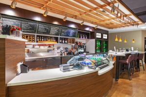 a restaurant with a counter and a bar with a counter at Courtyard by Marriott Tulsa Woodland Hills in Tulsa
