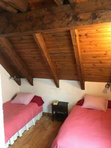 2 Betten in einem Zimmer mit Holzdecken in der Unterkunft Duplex muy luminoso en Vielha con parking in Vielha e Mijaran