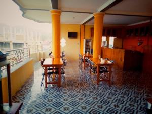 a restaurant with tables and chairs and a balcony at FIFAWIND HOTEL in Labuan Bajo