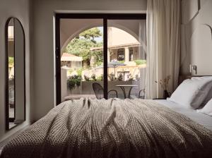 ラガナスにあるHotel Pallasのベッドと大きな窓のある寝室