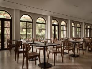 un comedor con mesas, sillas y ventanas en Hotel Pallas, en Laganas