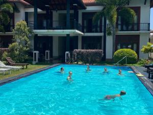 a group of people swimming in a swimming pool at Christima Residence in Negombo