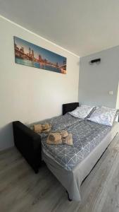 a bedroom with a bed with a picture on the wall at Apartament U Waldka in Mechelinki