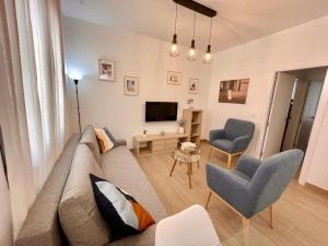 een woonkamer met een bank, 2 stoelen en een televisie bij El Umbral de Muñices in Córdoba