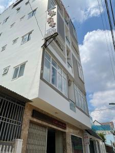 a white building with a balcony on top of it at Anh Phat Hotel in Buon Ma Thuot