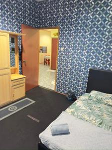um quarto com uma cama e uma parede azul e branca em VIE HOMESTAY TAWAU em Tawau