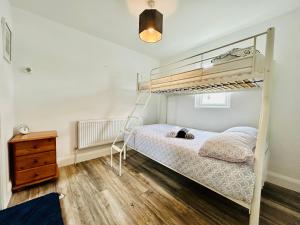 a bedroom with a bunk bed and a wooden floor at Ocean View Apartment - Connemara in Galway