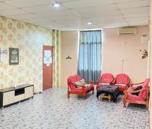 a waiting room with red chairs and a tv at VIE HOMESTAY TAWAU in Tawau