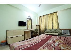 een hotelkamer met een groot bed en een bureau bij Vishal Hotel, Katra in Katra