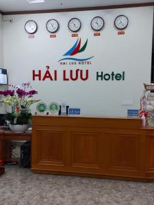 Una señal en una pared con relojes. en Hải Lưu Hotel, en Cái Rồng