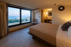 um quarto com uma cama grande e uma janela grande em Marni Village em Hersonissos