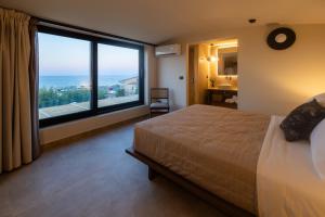 a bedroom with a large bed and a large window at Marni Village in Hersonissos